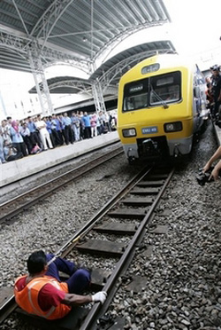 Rathakrishnan Velu attempts to pull with his teeth a seven-coach train with a combined weight of 297.1 tonnes. (AP Photo/Vincent Thian) 